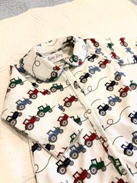 Bobbie's Shoppe white footed pajamas with a repeating print of red, blue, and green tractors. Scalloped collar.