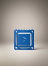 Bobbie's Shoppe blue mahjong pool mat with white bottom and heart graphic. Scalloped edges with text.